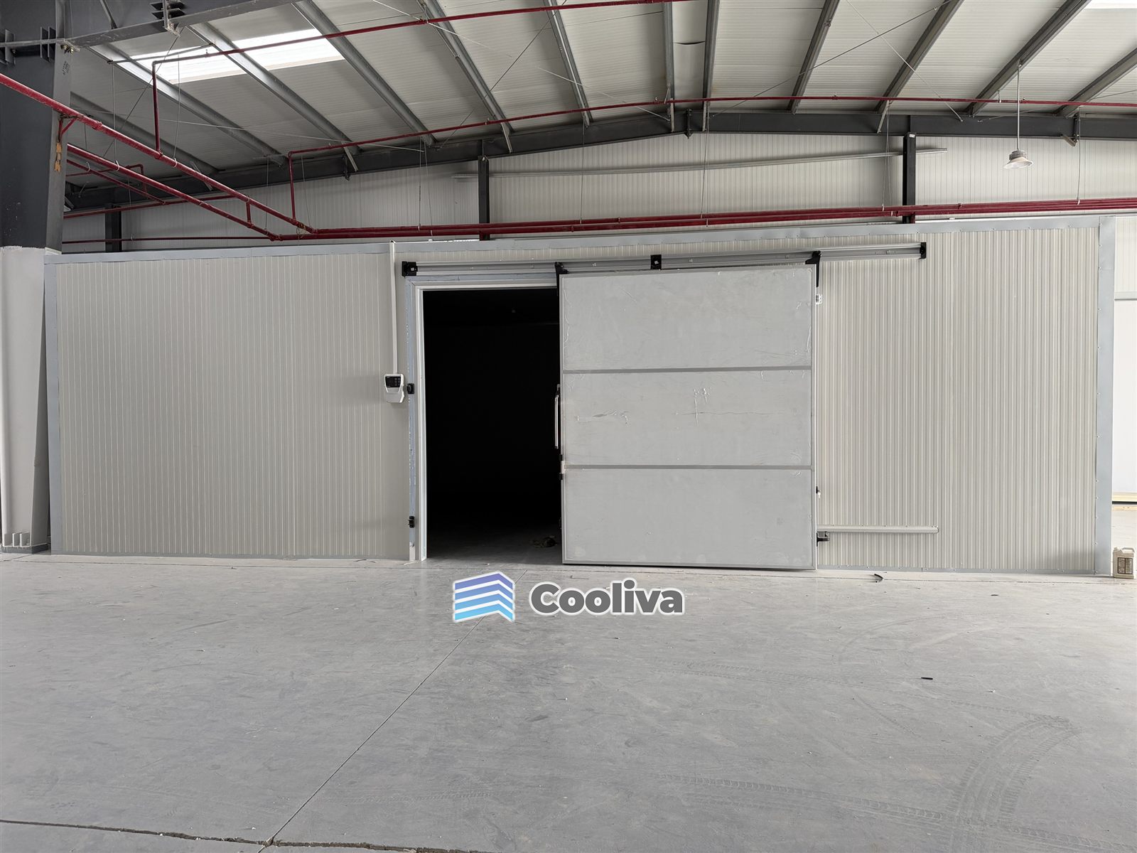 غرفة تخزين بارد داخل مستودع بباب سحّاب ولوحة تحكم بدرجة الحرارة | Warehouse cold storage room with sliding door and temperature controller
